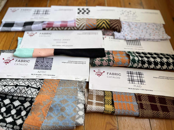 Collection of fabric swatches and catalogs on a wooden surface